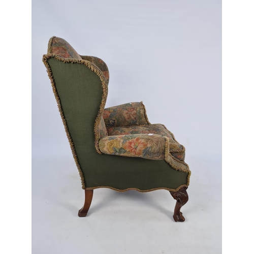 19 - A VICTORIAN WING BACK ARMCHAIR WITH CARVED MAHOGANY BALL AND CLAW FEET AND FLORAL UPHOLSTERY - MEASU... 