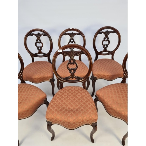 41 - A SET OF SIX VICTORIAN MAHOGANY FRAMED BALLOON BACKED DINING CHAIRS EACH WITH A SHAPED AND CARVED BA... 