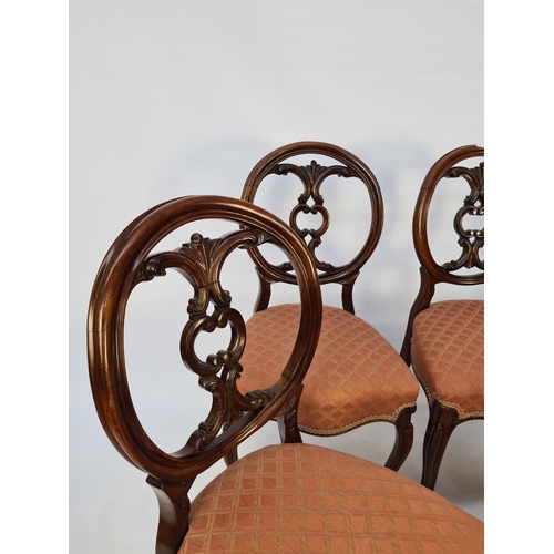 41 - A SET OF SIX VICTORIAN MAHOGANY FRAMED BALLOON BACKED DINING CHAIRS EACH WITH A SHAPED AND CARVED BA... 