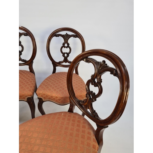 41 - A SET OF SIX VICTORIAN MAHOGANY FRAMED BALLOON BACKED DINING CHAIRS EACH WITH A SHAPED AND CARVED BA... 