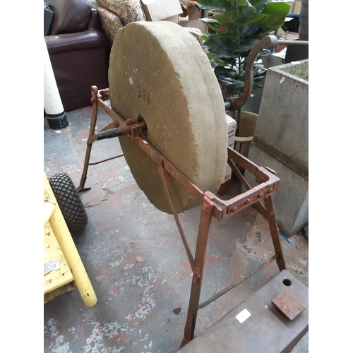 388 - A VICTORIAN HAND OPERATED SANDSTONE GRINDING WHEEL ON WROUGHT IRON BASE