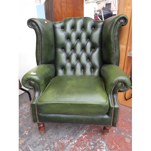 775 - A CHESTERFIELD STYLE GREEN LEATHER WING BACK ARMCHAIR