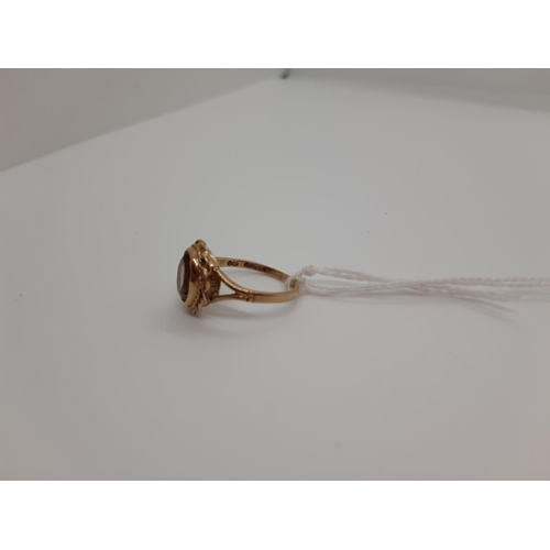 73 - A HALLMARKED 9CT GOLD LADIES RING WITH INSET OVAL CUT GLASS CENTRE AND REPEATED ROPE SURROUND - SIZE... 