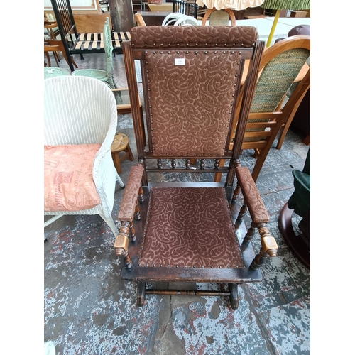 774 - A TURN OF THE CENTURY AMERICAN MAHOGANY FRAMED ROCKING CHAIR WITH BROWN UPHOLSTERED SEAT AND BACK