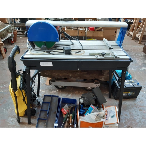 438 - A BLACK AND BLUE MAINS ELECTRIC TILE CUTTER ON HEAVY DUTY STAND