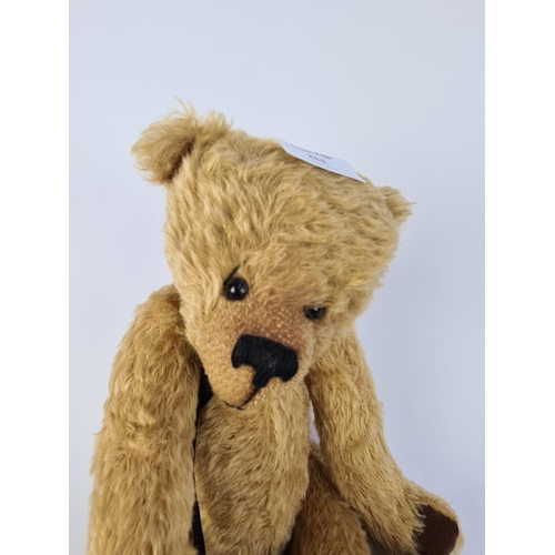 261 - A VINTAGE STYLE BLONDE TEDDY BEAR WITH BLACK RIBBON