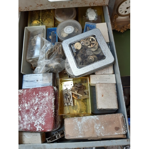 153 - A VINTAGE METAL EIGHT DRAWER FILING CABINET CONTAINING A LARGE COLLECTION OF WATCHMAKERS PARTS AND A... 