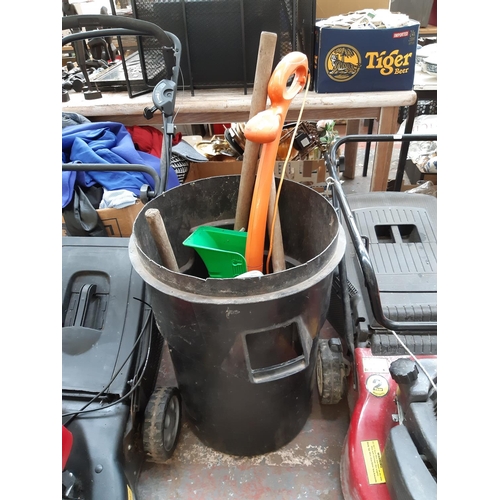 316 - A PLASTIC DUSTBIN CONTAINING A FLYMO CONTOUR ELECTRIC STRIMMER, WOODEN SHAFTED SLEDGEHAMMERS, SPADE ... 