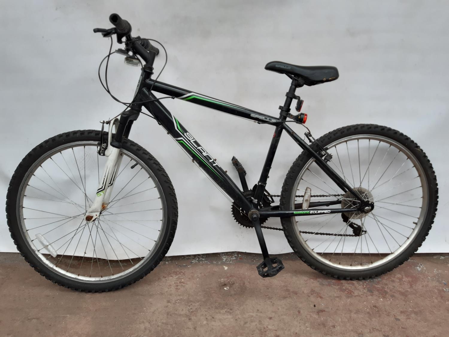 A BLACK APOLLO SLANT MENS MOUNTAIN BIKE WITH FRONT SUSPENSION AND 18 SPEED SHIMANO GEAR SYSTEM