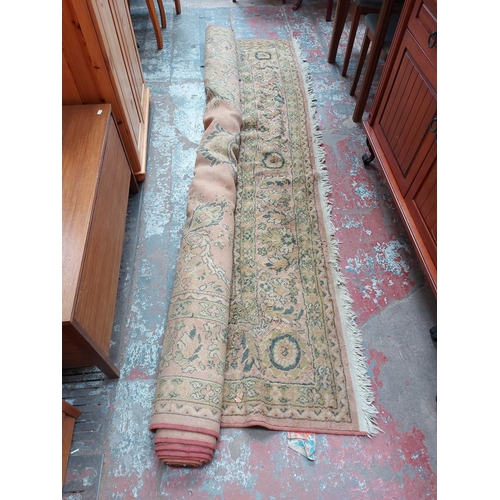 921 - A VINTAGE PINK FLORAL PATTERNED RUG WITH TASSLE EDGE