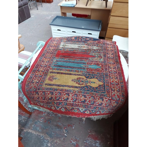 924 - TWO VINTAGE RUGS TO INCLUDE AN AFGHAN HERAT TRIBAL PATTERNED RUG AND A RED FLORAL PATTERNED RUG WITH... 