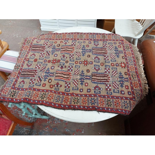 924 - TWO VINTAGE RUGS TO INCLUDE AN AFGHAN HERAT TRIBAL PATTERNED RUG AND A RED FLORAL PATTERNED RUG WITH... 