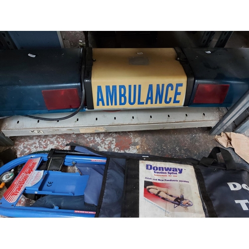 103 - FOUR ITEMS TO INCLUDE A SET OF VINTAGE BLUE FLASHING AMBULANCE LIGHTS AND THREE LEG TRACTION SPLINTS