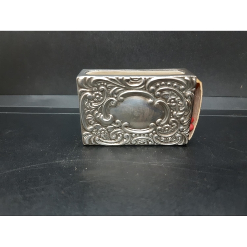 134 - An early 20th century hallmarked Birmingham silver matchbox holder with embossed design and clear ca... 
