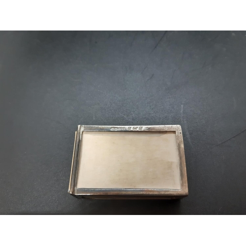 134 - An early 20th century hallmarked Birmingham silver matchbox holder with embossed design and clear ca... 