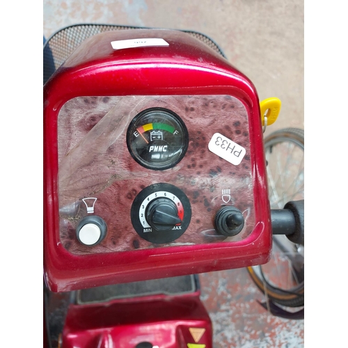 266 - A red Rascal ride on four wheeled mobility scooter with key, battery and charger (switches on, drive... 