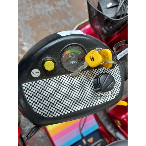 267 - A red Sterling Pearl four wheeled ride on mobility scooter with two keys, battery, charger and instr... 