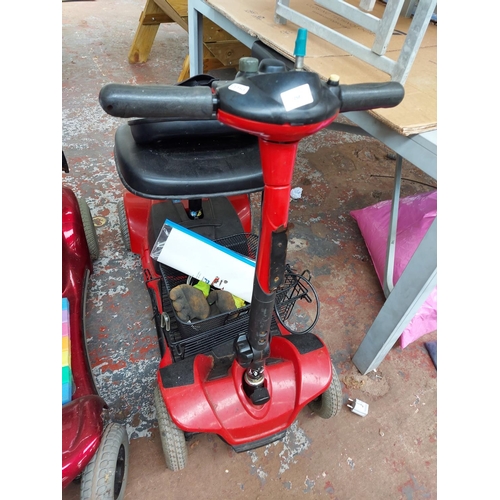 268 - A black and red lightweight Pride four wheeled ride on mobility scooter with battery, charger and in... 