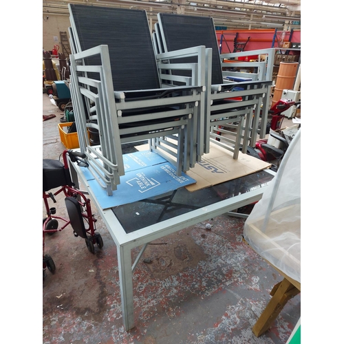 269 - A nine piece aluminium patio set comprising large smoked glass square table - measuring approx. 54