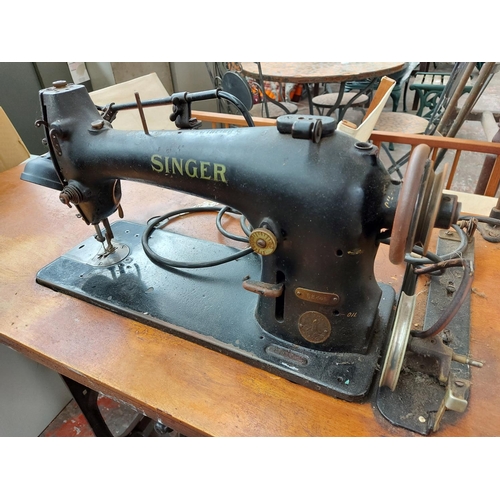 287 - A vintage Singer industrial pedal powered sewing machine with wooden top and heavy cast iron base wi... 
