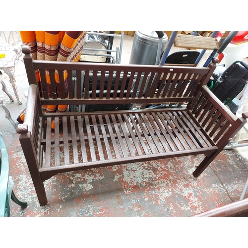 291 - An early 20th century English wooden slatted three seat garden bench