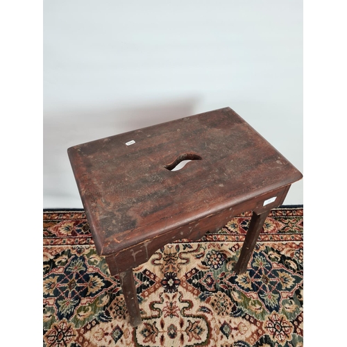 234 - An 18th century stained pine four legged tall farmhouse stool with central handle to top - measuring... 