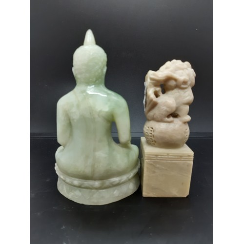 69 - Two oriental ornaments to include a carved jade effect Thai Buddha together with a carved soap stone... 