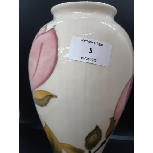 5 - A Moorcroft pottery vase in the pink magnolia pattern on cream ground - measuring approx. 26cm tall