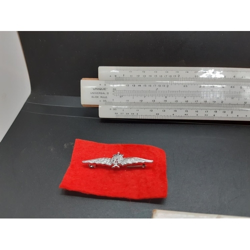 70 - Two items to include a cased ‘unique’ universal II slide rule and a modern RAF brooch