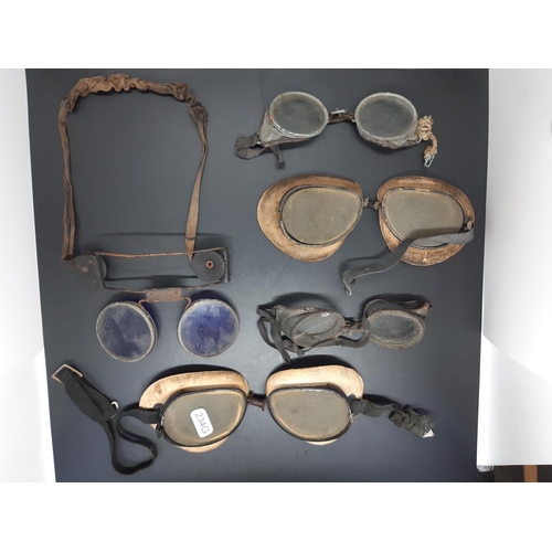 78 - A collection of four early automobile driving goggles together with a pair of antique welding goggle... 