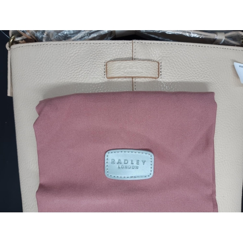 87 - An as new ladies ‘Radley London’ cream leather shoulder / hand bag - complete with original dust cov... 