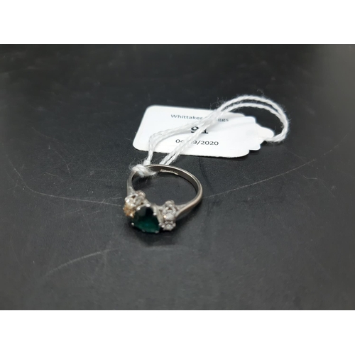 91 - A hallmarked  18ct platinum ladies ring with large inset emerald and four surrounding diamonds - siz... 