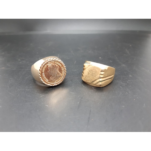 93 - Two large gold coloured gents rings, one with inset replica Queen Victoria sovereign and one other