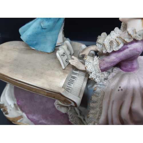 14 - A late 19th/early 20th century Sitzendorf style porcelain figurine of two musicians, a lady playing ... 