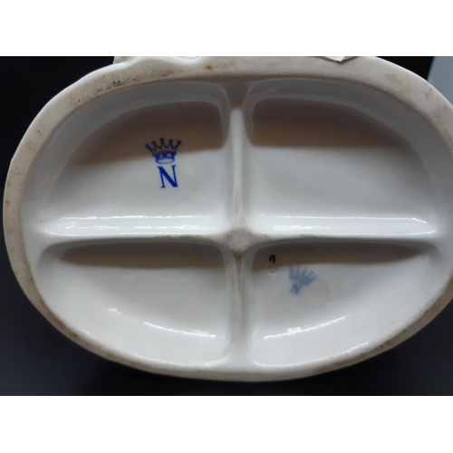 18 - A possibly German continental porcelain figurine of seated boy and girl with initial below five poin... 