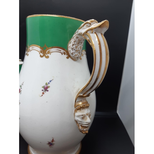 29 - A Victorian porcelain pitcher with serpent handle, satire faced spout with well detailed hand painte... 