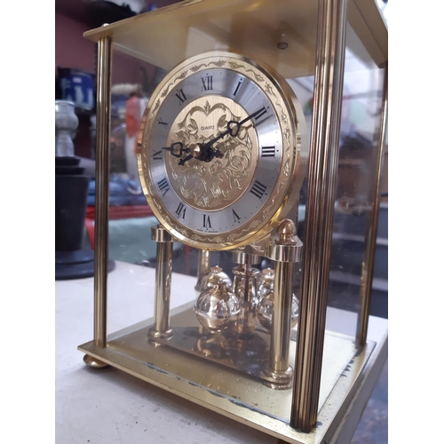 107 - Two vintage clocks to include a brass and glass cased Kundo style anniversary example and a Metamec ... 