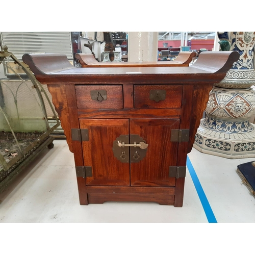 110 - A modern oriental influenced hardwood miniature cabinet/stool with two doors, two drawers and aged b... 