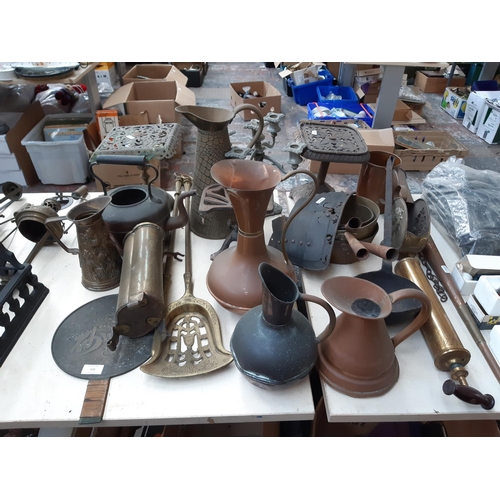 122 - A large collection of mixed metalware to include a set of three graduating saucepans, copper jug, de... 