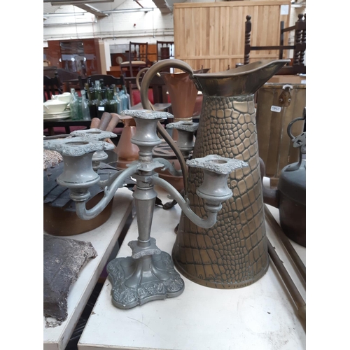 122 - A large collection of mixed metalware to include a set of three graduating saucepans, copper jug, de... 