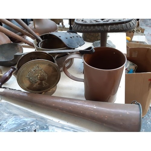 122 - A large collection of mixed metalware to include a set of three graduating saucepans, copper jug, de... 