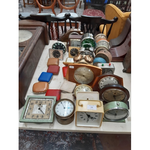 130 - A large collection of various travel and mantel clocks to include a Metamec teak cased wind up examp... 