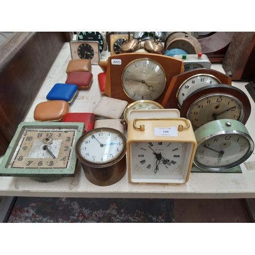 130 - A large collection of various travel and mantel clocks to include a Metamec teak cased wind up examp... 