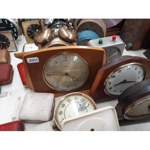 130 - A large collection of various travel and mantel clocks to include a Metamec teak cased wind up examp... 