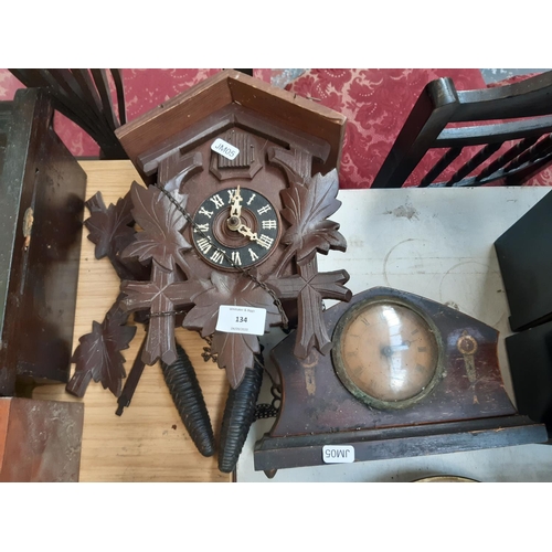 134 - Two clocks to include an oak effect cuckoo clock with weights and an Edwardian inlaid oak wind up ma... 