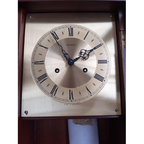 136 - A mahogany cased Metamec chiming wall clock with brass dial, key and pendulum