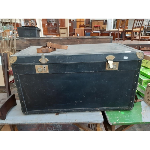 149 - A 1940s black canvas travel trunk with two concealed suitcases