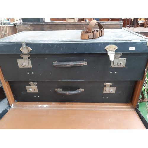 149 - A 1940s black canvas travel trunk with two concealed suitcases