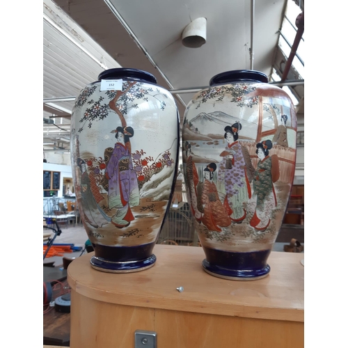 152 - A pair of Japanese Meiji period vases of ovoid form ranging from a tapered foot detailed with panels... 