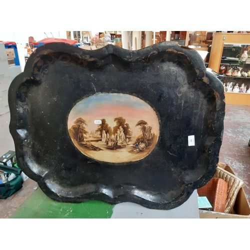 195 - A large Victorian black paper mache serving tray with etched transfer printed centre depicting an En... 